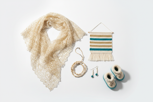 Finished silk yarn projects flat lay — lace shawl, wall hanging, jewellery and baby items — Knitsilk Europe